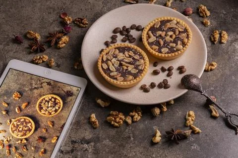 Delicious composition with two chocolate tarts and a tablet Stock Photos