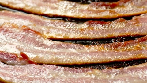 Delicious cooked bacon strips. Close-up of pork bacon slices on hot grilled pan. 스톡 동영상 334642104