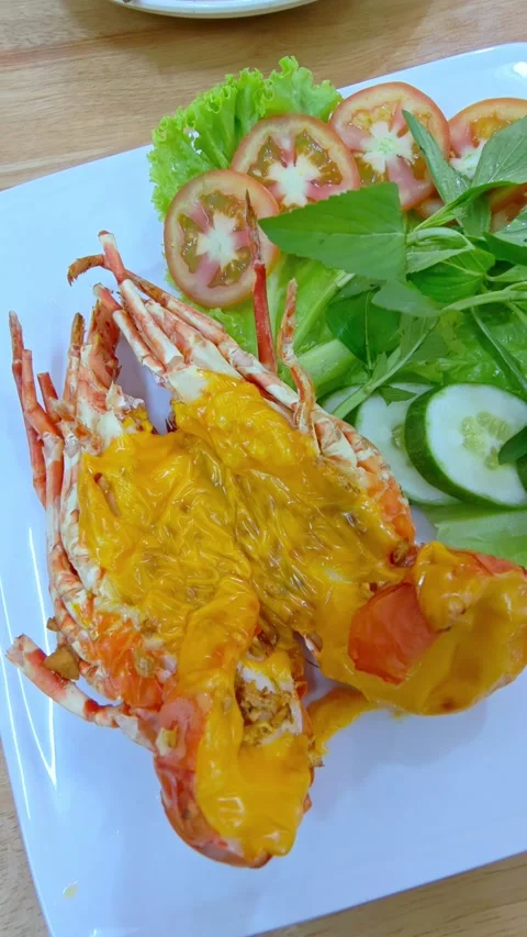 Delicious cooked lobster with a vegetable salad on a plate at a restaurant. Stockbeeldmateriaal 337221884