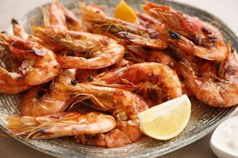 Delicious cooked shrimps served with lemon on plate, closeup Stock Photos