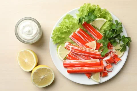 Delicious crab sticks served on wooden table, flat lay Stock Photos