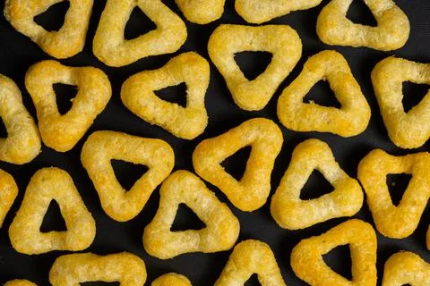 Delicious crispy corn chips triangular shape with spices on a black background Foto stock