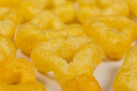 Delicious crispy corn chips triangular shape with spices, macro. Stock Photos