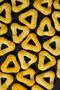 Delicious crispy corn chips triangular shape with spices on a black background 스톡 사진
