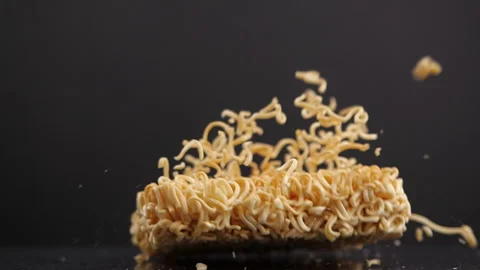 Delicious crispy instant noodles falling in slow motion on dark background Stock Footage 131693149