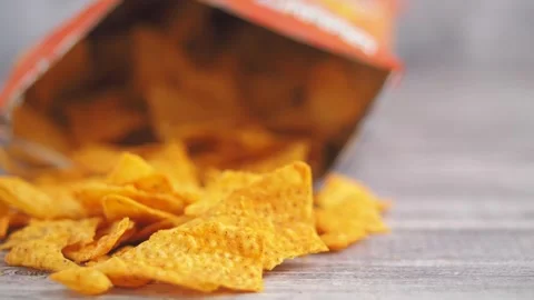 Delicious crunchy corn tortilla chips spilling out of an open bag onto a wo.. Stock Footage 333156748
