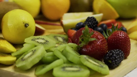 Delicious cut fruit on cutting board and tilting up to other fruit - slow Stock Footage 341234599