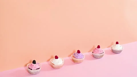 Delicious cute cup cakes with raspberry and cream appear in row. Stop motion Stock Footage 168480642