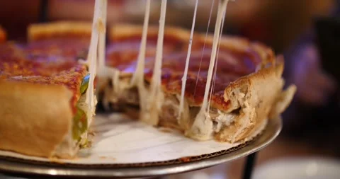 Delicious deep-dish pizza being served at a local restaurant in Chicago Vidéo 281705154