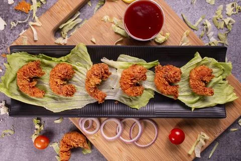 Delicious deep fried breaded cheese prawn on black plate on wooden table. sel Stock-Fotos