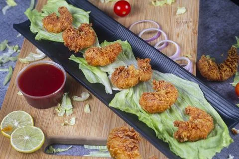 Delicious deep fried breaded cheese prawn on black plate on wooden table. sel Foto stock