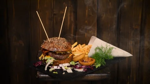Delicious dinner with Cheeseburger, chips and onion rings Stock Footage 104667538