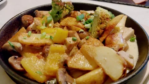 Delicious dish in a frying pan stewed potatoes with meat, mushrooms and Stock Footage 303621205