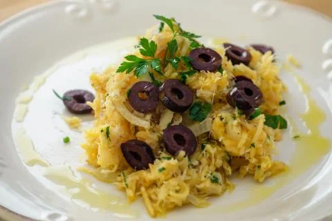 A delicious dish of shredded cod, with potato straw, mixed egg and dark olive Stock Photos
