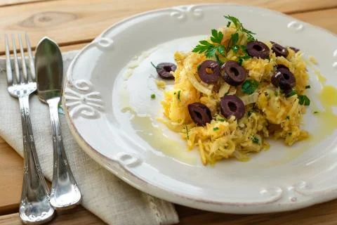 A delicious dish of shredded cod, with potato straw, mixed egg and dark olive Foto stock