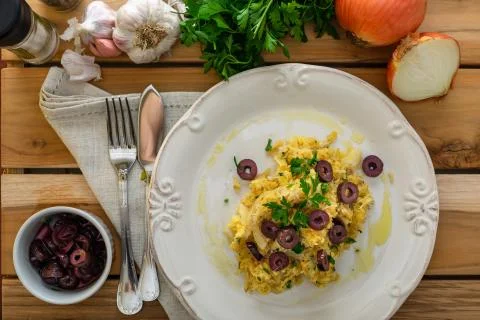 A delicious dish of shredded cod, with potato straw, mixed egg and dark olive Stock Photos