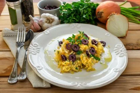 A delicious dish of shredded cod, with potato straw, mixed egg and dark olive Stock Photos