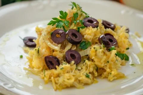 A delicious dish of shredded cod, with potato straw, mixed egg and dark olive Stock Photos