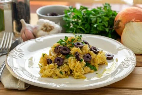 A delicious dish of shredded cod, with potato straw, mixed egg and dark olive Stock Photos