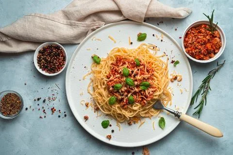 Delicious dish with spaghetti and meat bolognese sauce on a gray-blue background Stock Photos