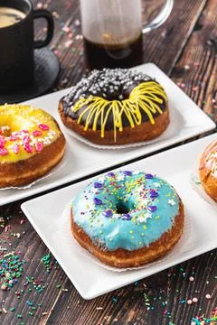 Delicious donuts decorated with different decorations on wooden table Stock Photos