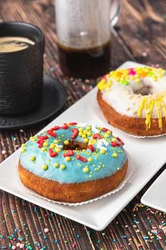 Delicious donuts decorated with different decorations on wooden table Stock Photos