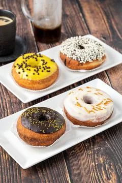 Delicious donuts decorated with different decorations on wooden table Stock Photos