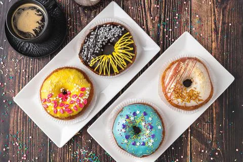 Delicious donuts decorated with different decorations on wooden table Stock Photos