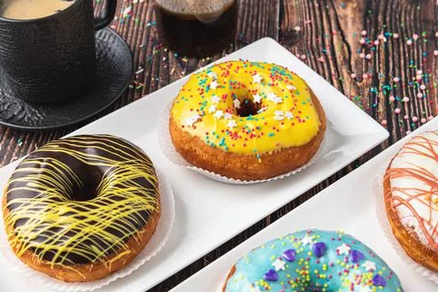 Delicious donuts decorated with different decorations on wooden table Stock Photos