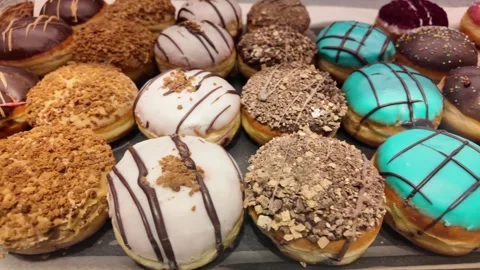 Delicious donuts displayed in a bakery case for customers to choose Stock Footage 346017424
