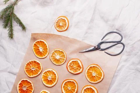 Delicious dried orange on baking sheet and white linen Christmas decoration Stock Photos