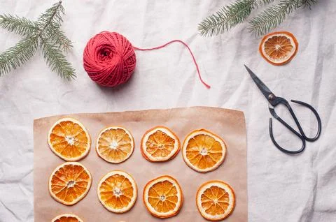 Delicious dried orange on baking sheet and white linen Christmas decoration Stock Photos
