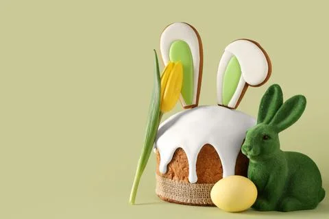 Delicious Easter cake with bunny ears, painted egg and tulip flower on green  Stock Photos