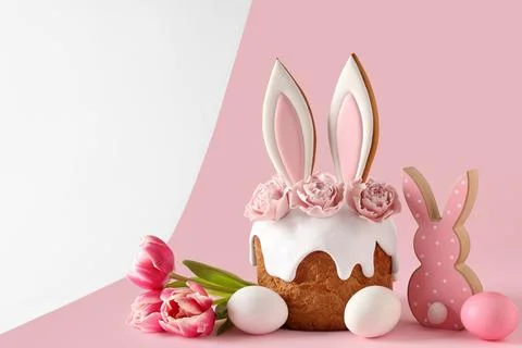 Delicious Easter cake with bunny ears, tulip flowers and painted eggs on colo Stock Photos