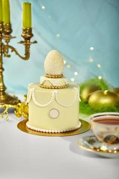 Delicious easter cake decorated with white chocolate egg and gold details Stock Photos