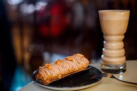 Delicious eclair with caramel glaze and latte. Beautiful dessert. Stock Photos