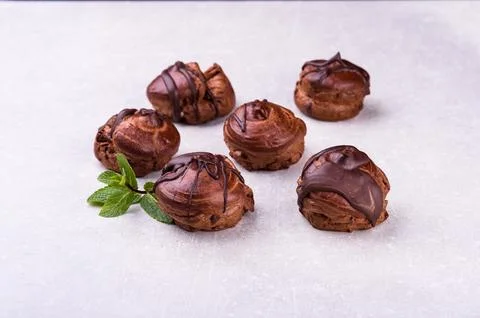 Delicious eclair covered with chocolate isolated on white, top view Stock Photos