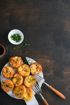 Delicious egg muffins with green onions, bacon, cheese and tomatoes on wooden Stock Photos