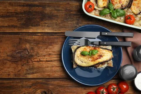 Delicious eggplant lasagna served on wooden table, flat lay. Space for text Stock Photos