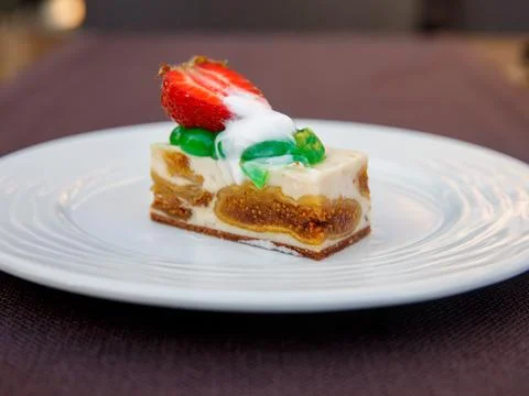 Delicious fig mousse cake slice with white chocolate cream and strawberry on  Stock Photos