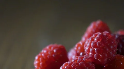 Delicious first class raspberries heap on wooden table Stock Footage 98980285