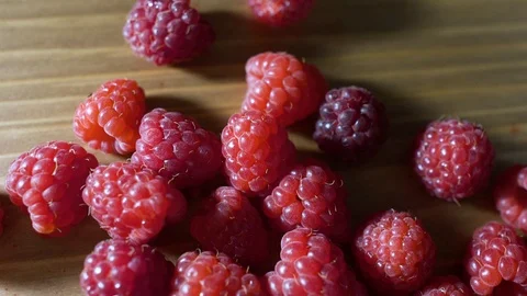 Delicious first class raspberries heap on wooden table Stock-Footage 98980932