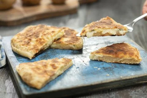 Delicious flatbread with potatoes and cheese. Stock Photos