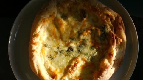 Delicious four cheese pizza rotating on a plate Video stock 337548610