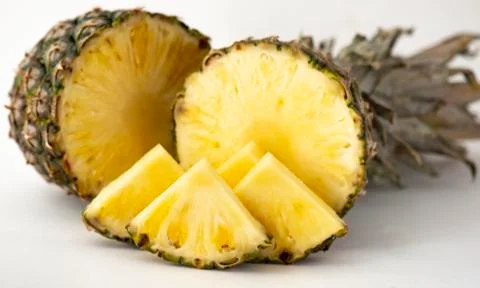 Delicious fragrant appetizing pineapple cut into slices for dessert with a li Stock Photos