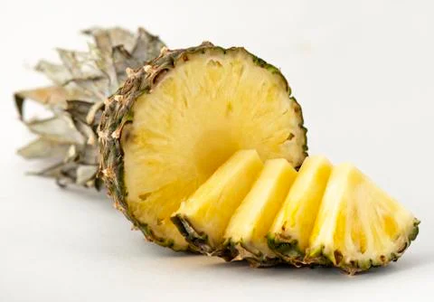 Delicious fragrant appetizing pineapple cut into slices for dessert with a li Stock Photos
