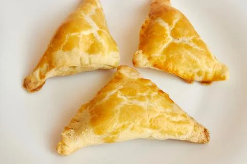 Delicious fragrant triangular baked cakes on a white plate Stock Photos