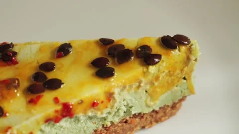 Delicious fresh baked multi-layered passionfruit cheesecake slice on white plate Stock Footage 313961555