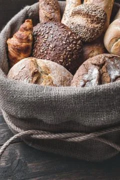 Delicious fresh bread inside a sack on wooden background Stock Photos