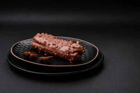 Delicious fresh eclair cake or profiterole with chocolate and nuts Stock-Fotos